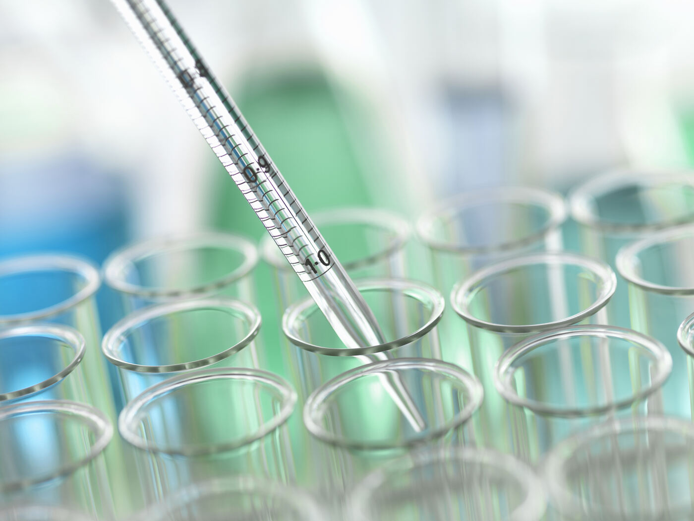 A pipette dispensing samples into a multi-well laboratory plate